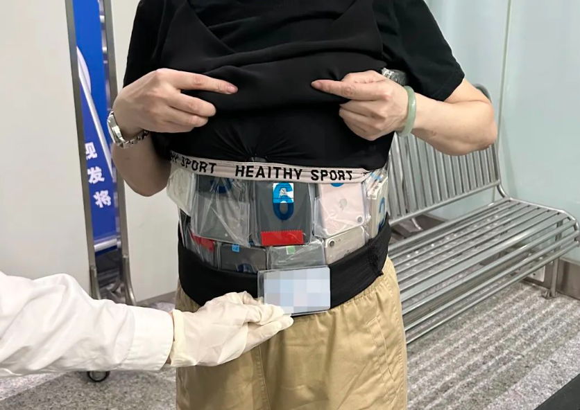神色慌张 + 步态异常,2 名旅客身藏 106 台手机入境被查