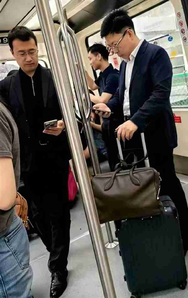 网友机场摆渡车偶遇余承东、何刚：自己拿行李箱 专注看手机